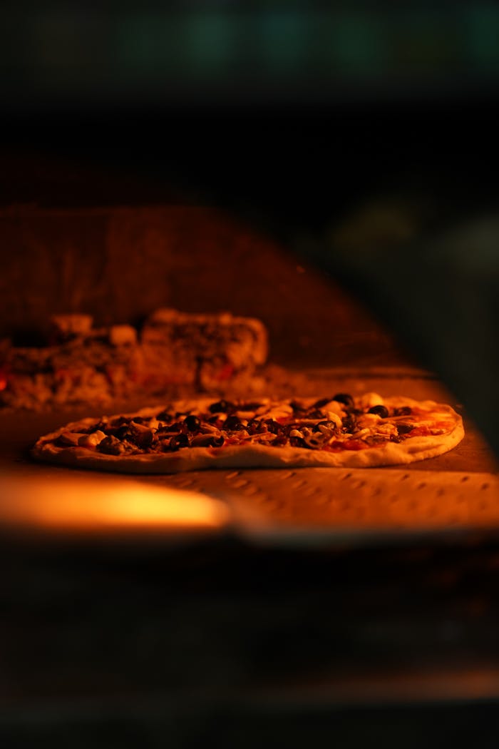 Close-up of wood-fired pizzas baking in a New Delhi pizzeria, capturing the warm glow.